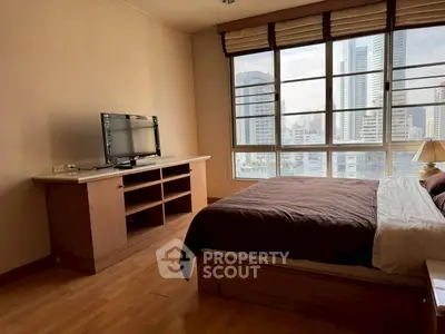 Spacious bedroom with city view and modern furnishings in high-rise apartment