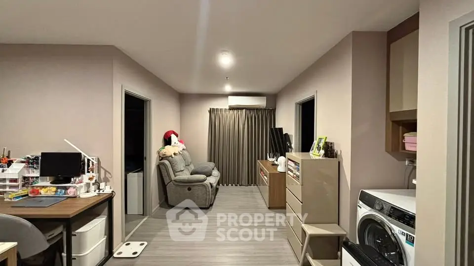 Modern living room with cozy seating and integrated workspace, featuring sleek flooring and contemporary decor.