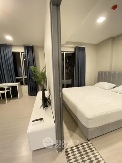 Modern bedroom with sleek design and adjacent study area in a stylish apartment