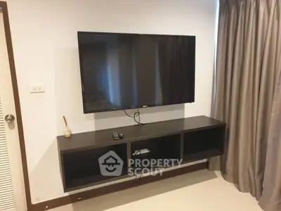 Modern living room with wall-mounted TV and sleek storage unit