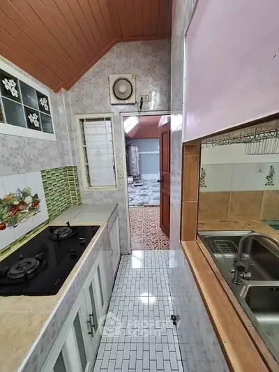 Charming kitchen with gas stove and unique tile design, featuring open layout and wooden ceiling accents.