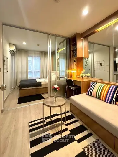 Modern studio apartment with stylish decor, featuring a cozy living area and a comfortable bedroom.
