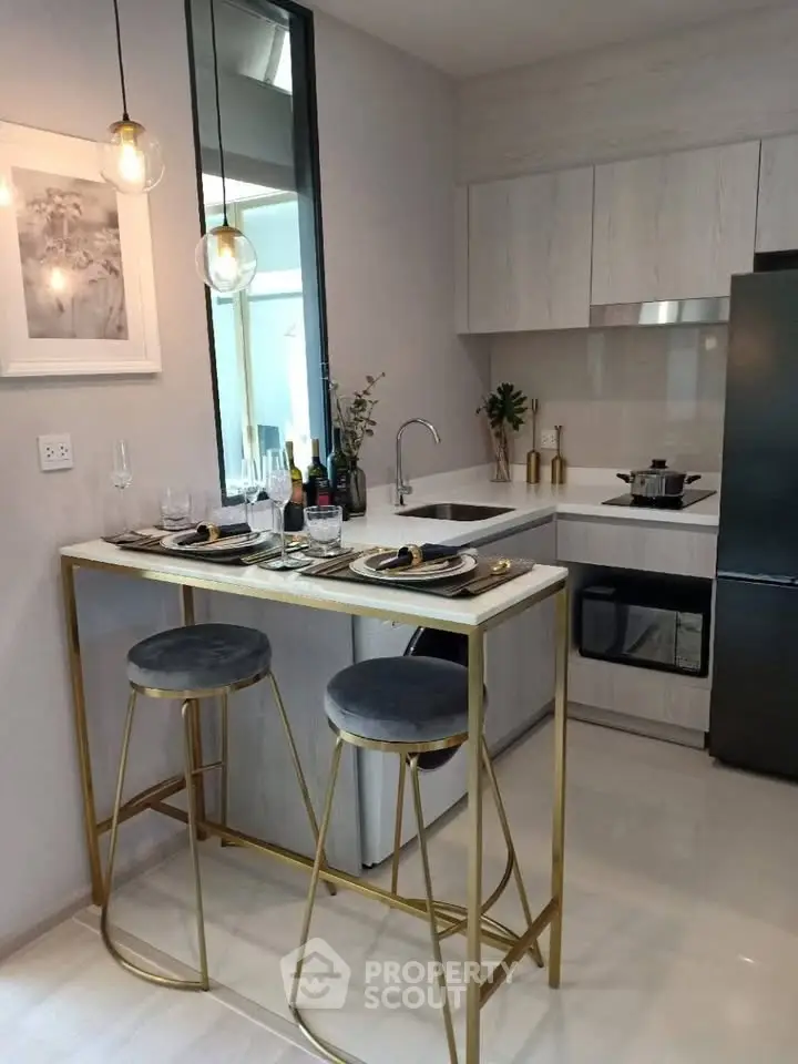 Modern kitchen with sleek design, featuring a compact dining area and stylish appliances.