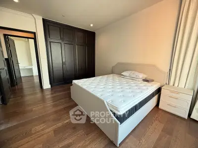 Spacious bedroom with elegant wooden flooring and large wardrobe