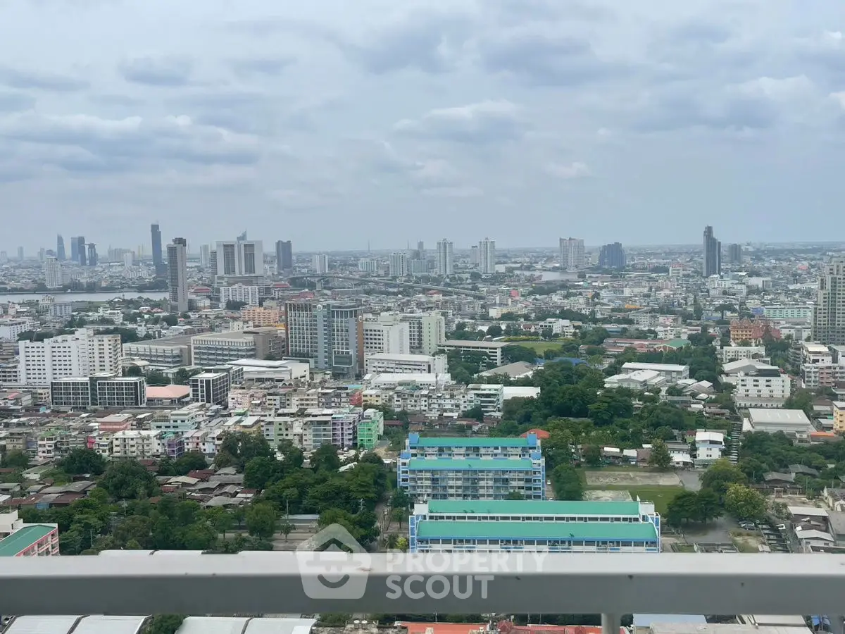 Stunning cityscape view from a high-rise balcony, showcasing urban skyline and greenery.