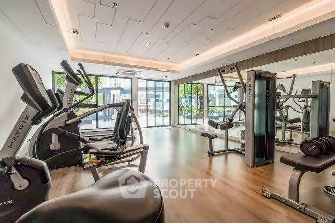 Modern gym with state-of-the-art fitness equipment and large windows for natural light.