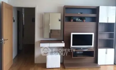 Modern living room with sleek wooden furniture and TV setup