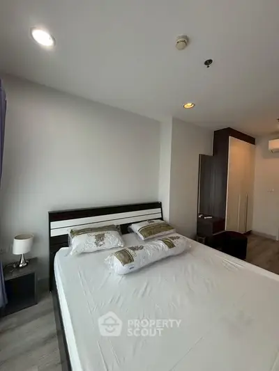 Modern bedroom with sleek furniture and ambient lighting in a contemporary apartment.