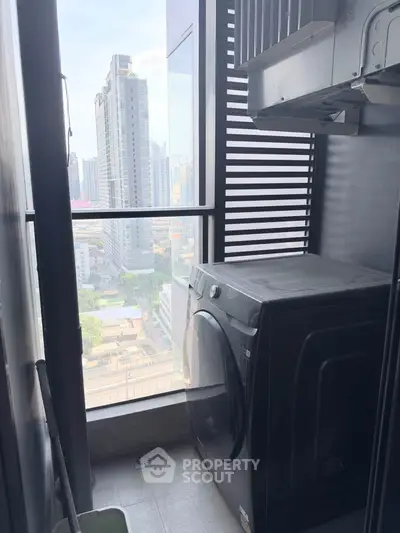 High-rise apartment balcony with washer and city view