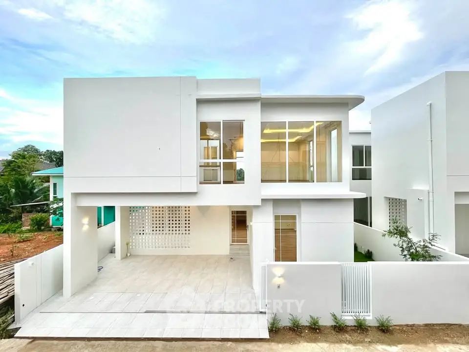 Modern two-story white house with large windows and spacious driveway