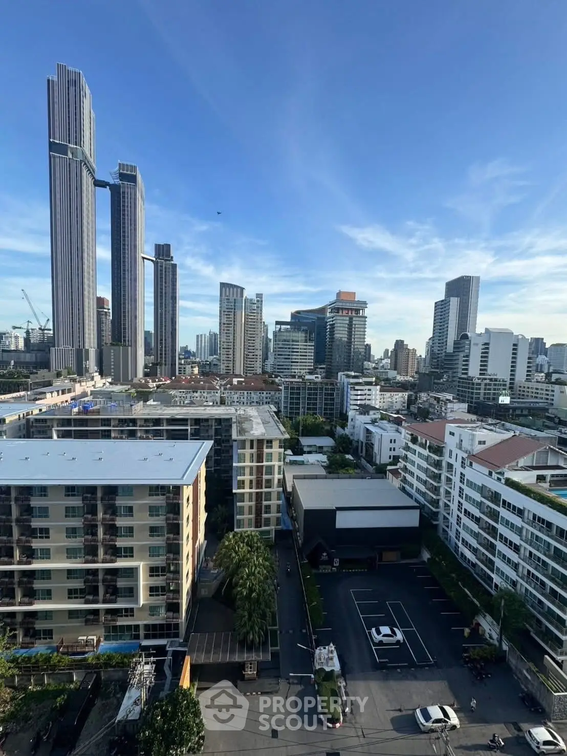 Stunning cityscape view showcasing modern skyscrapers and residential buildings under a clear blue sky.