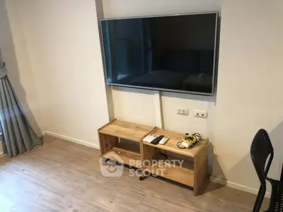 Modern living room with wall-mounted TV and stylish wooden furniture.