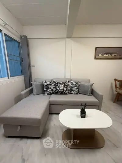 Cozy living room with modern sofa and stylish decor in a bright apartment.