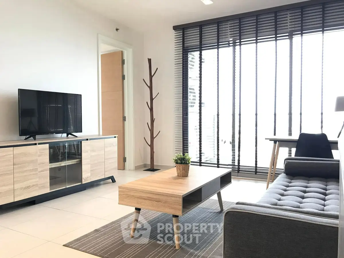 Modern living room with sleek furniture and large windows offering abundant natural light.