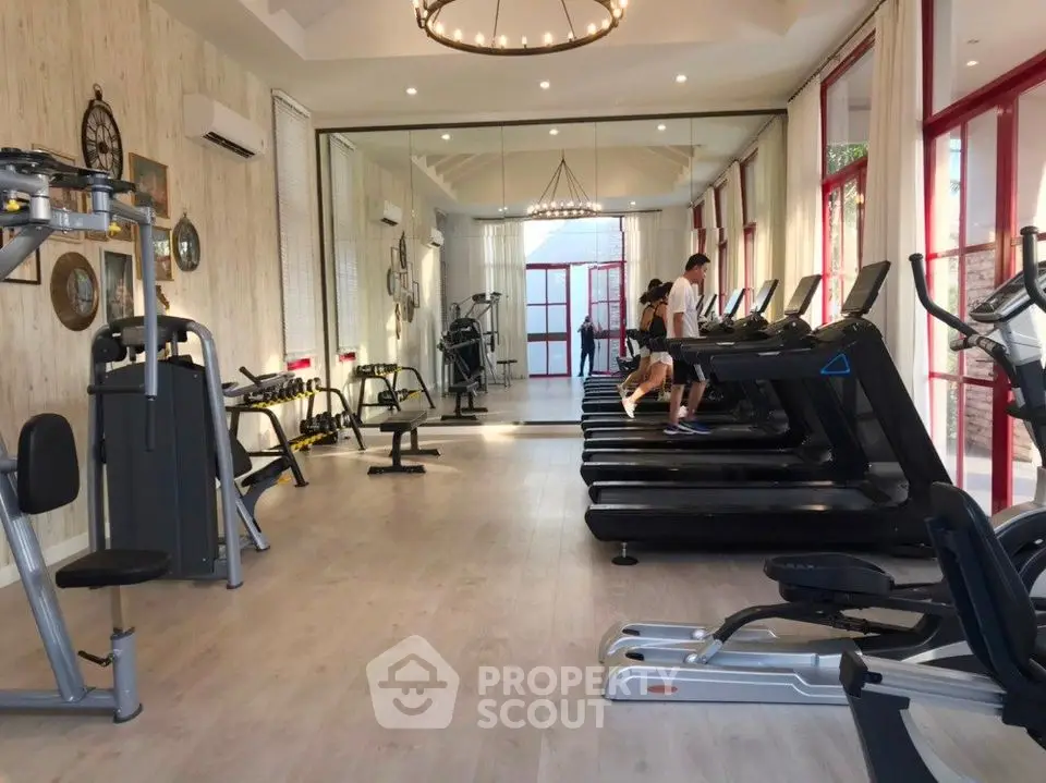 Spacious gym with modern equipment and elegant lighting in luxury property