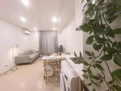 Modern living room with cozy seating and dining area, featuring stylish decor and natural lighting.
