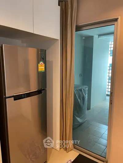 Modern kitchen with stainless steel fridge and balcony access