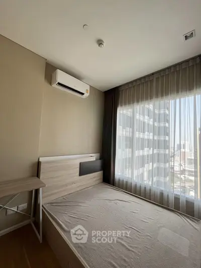 Modern bedroom with large window and air conditioning in urban apartment