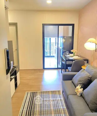 Cozy living room with modern decor and balcony access in a stylish apartment.