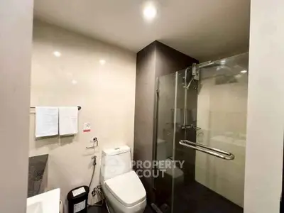 Modern bathroom with glass shower and sleek fixtures in a contemporary home.