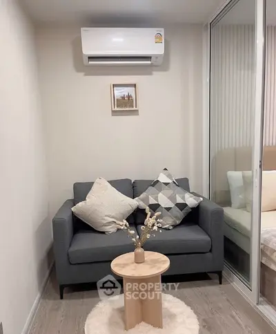Cozy living room with modern sofa and air conditioning, perfect for relaxation.