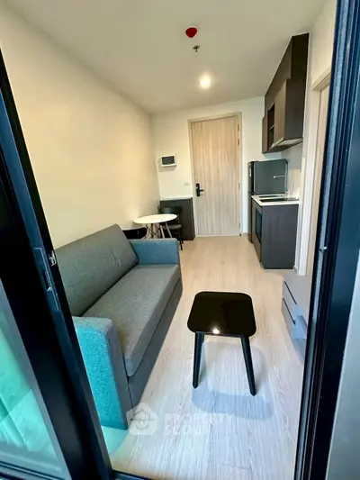 Modern compact living room with kitchenette and stylish furniture in a cozy apartment.