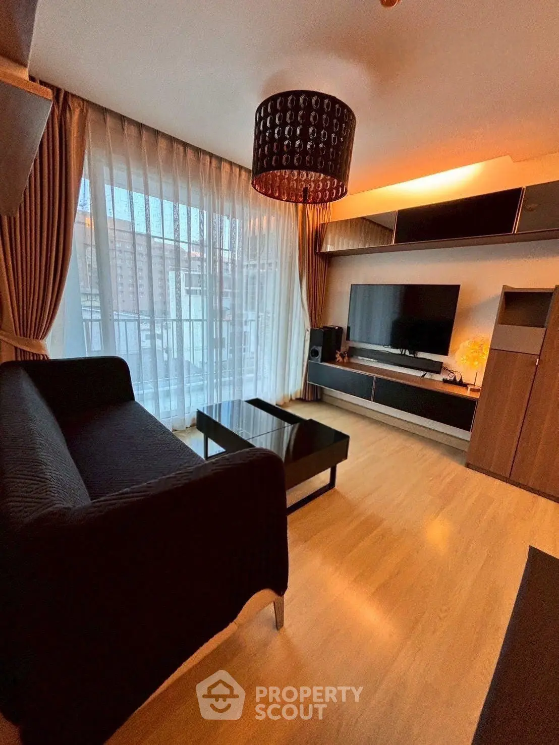 Modern living room with large window, stylish furniture, and wooden flooring.