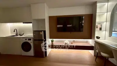 Modern living room with sleek kitchen, built-in TV, and stylish furniture in a contemporary apartment.