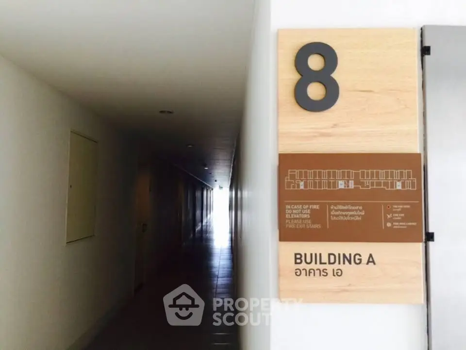 Modern building hallway with floor number sign and emergency exit plan.