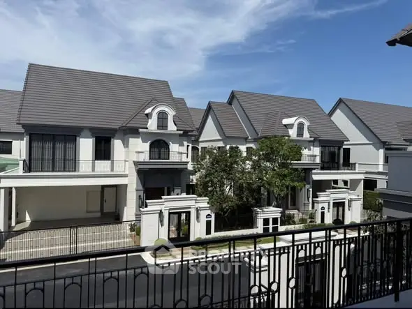 Luxurious residential homes with elegant architecture and manicured landscaping under a clear blue sky.