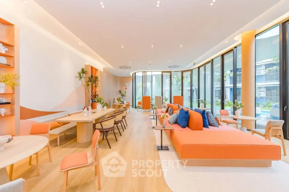 Spacious modern living room with floor-to-ceiling windows and stylish orange accents.