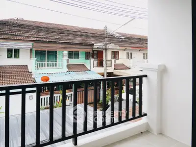 Charming balcony view of residential neighborhood with tiled roofs and vibrant facades.