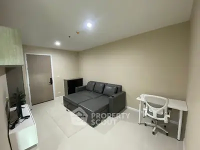 Modern living room with sleek furniture and neutral tones, perfect for relaxation and work-from-home setup.