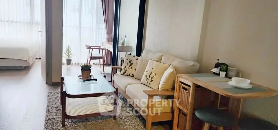 Charming living room with cozy sofa and dining area, adjacent to a bright bedroom.