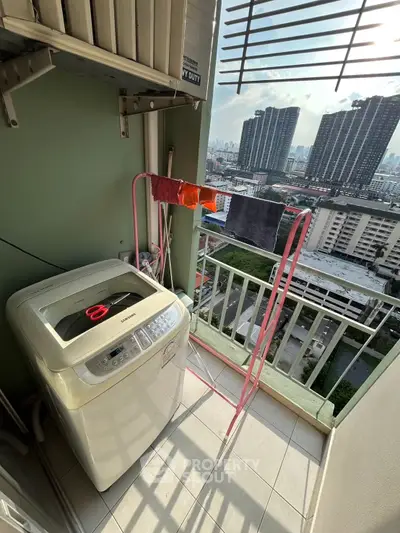 High-rise apartment balcony with washing machine and city view, perfect for urban living.