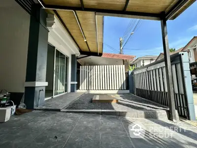 Modern house entrance with covered patio and gated driveway