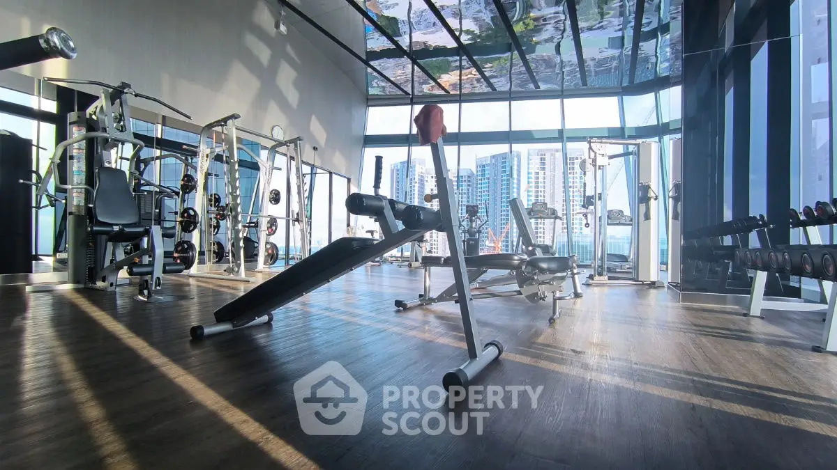 Spacious modern gym with city view in luxury residential building