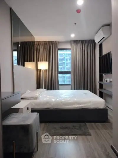 Modern bedroom with sleek design, featuring a large window and stylish furnishings.