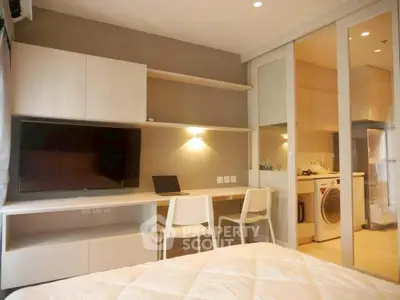 Modern bedroom with study area and in-room laundry facilities.