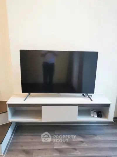 Modern living room with sleek TV stand and flat-screen television, perfect for entertainment setup.