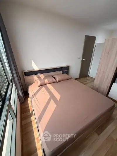 Cozy bedroom with natural light and modern furnishings in a stylish apartment.