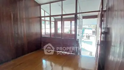 Charming wooden interior with large windows offering a bright and airy atmosphere.