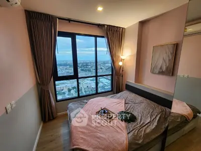 Cozy bedroom with stunning city view, modern decor, and large window for natural light.