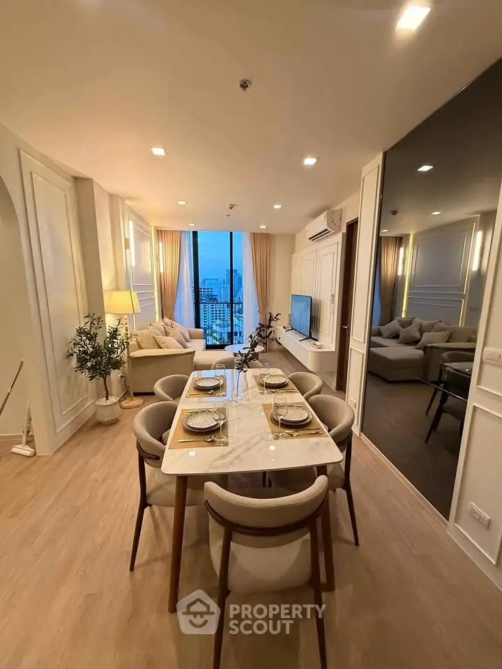 Luxurious modern living room with dining area and city view, featuring elegant decor and ample natural light.