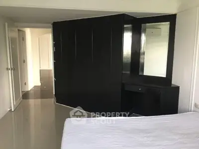 Spacious bedroom with modern black wardrobe and sleek flooring