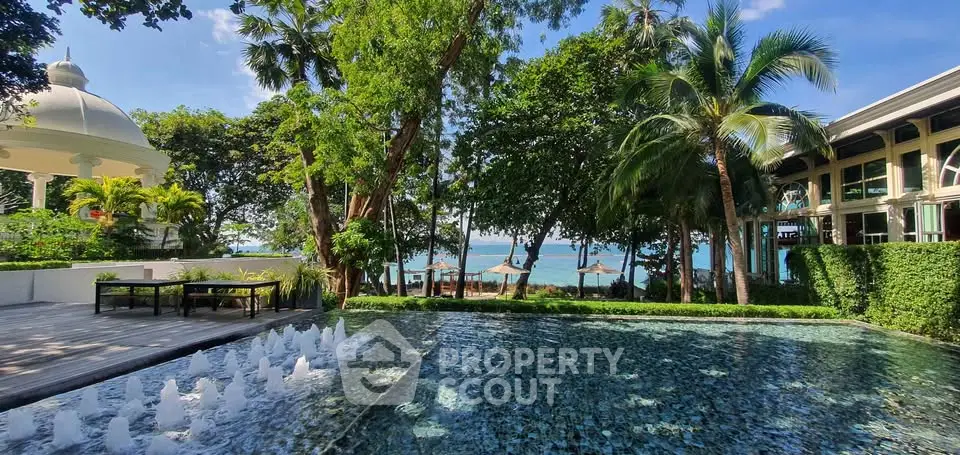 Luxurious beachfront property with stunning pool and lush greenery, offering a serene tropical escape.