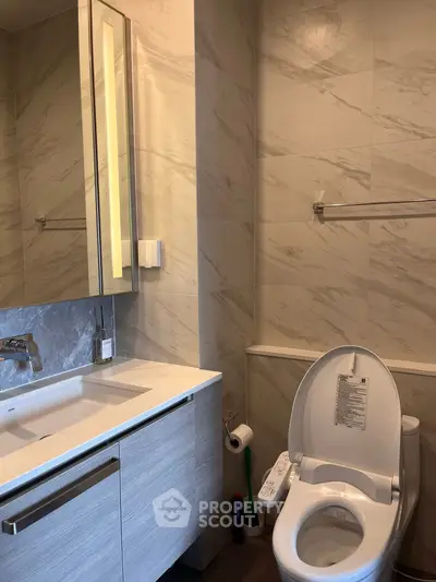 Modern bathroom with sleek vanity and high-tech toilet in luxury apartment.