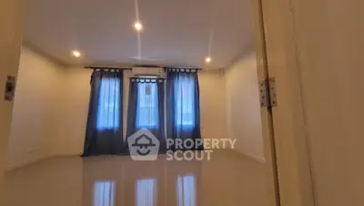Spacious living room with glossy tiled flooring, ample natural light, and elegant ceiling lights, perfect for modern living.