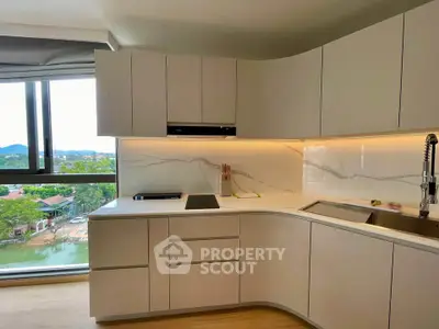 Modern kitchen with sleek cabinetry and scenic window view