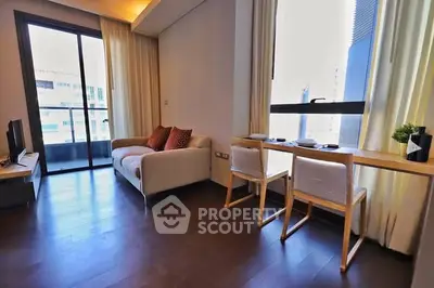 Modern living room with balcony access and stylish furniture in a high-rise apartment.